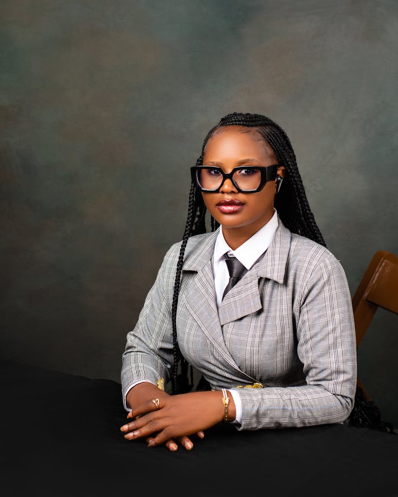 Portrait of a confident woman in business attire, seated against a neutral background.