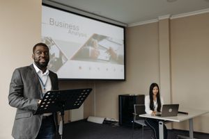 Business professionals presenting with projector and laptop in modern office.