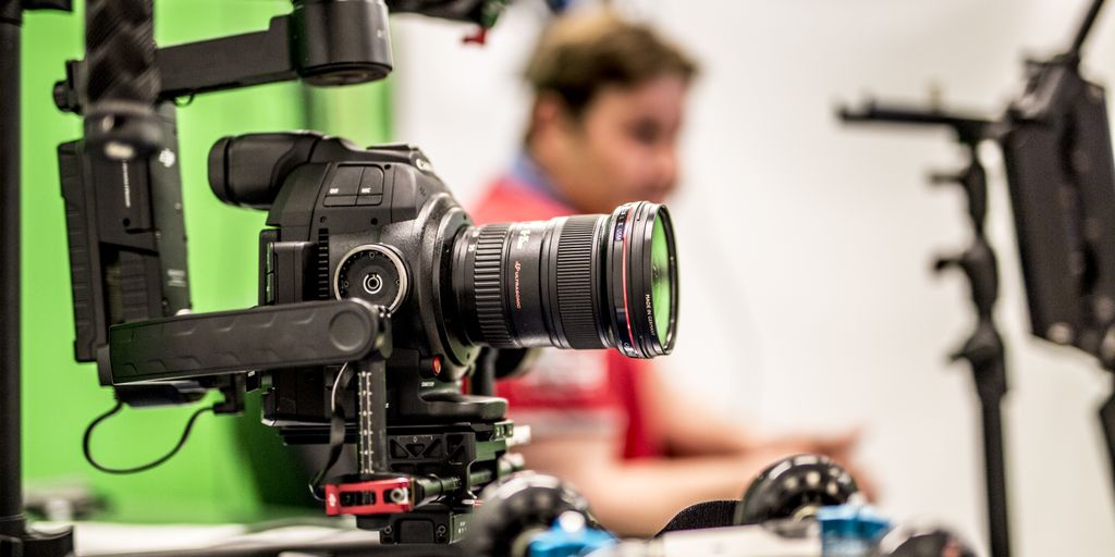 Close-up of a professional DSLR camera being used on a film set with blurred background.